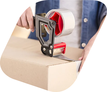 Une personne utilisant un ruban adhésif pour sceller un carton de déménagement