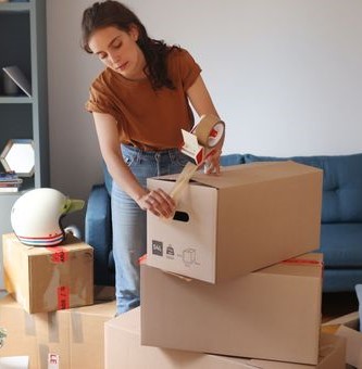 Une femme préparant ses cartons pour un déménagement à Bâle