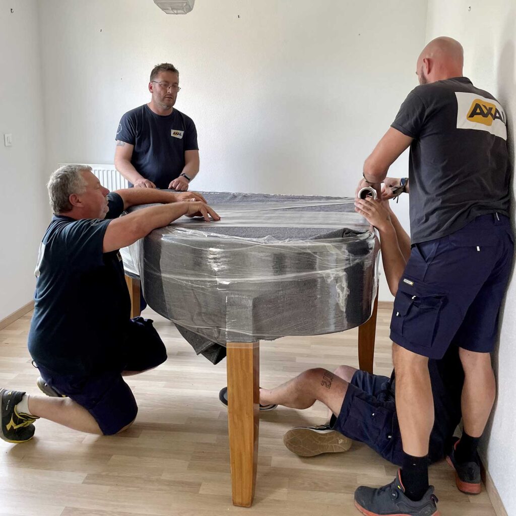 Pose d'un emballage de protection sur un piano avant son transport sécurisé